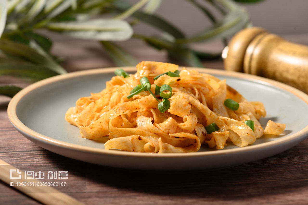 桌面上的盤子里的美味可口的紅油涼皮